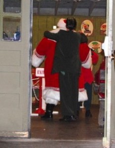 'Clarence' helps Santa with his coat.